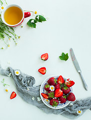 Image showing Fresh strawberry fruits, flowers, leaves on white wood table background