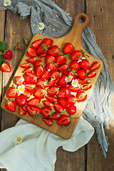 Image showing Fresh strawberry fruits, flowers, leaves on white wood table background