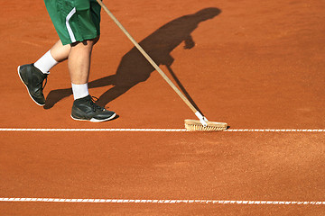 Image showing Worker cleans a line of tennis court