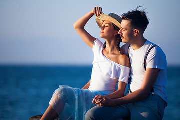 Image showing Happy young romantic couple relaxing on the beach watching the sunset