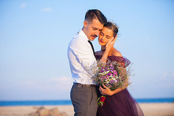 Image showing Young romantic couple relaxing on the beach watching the sunset