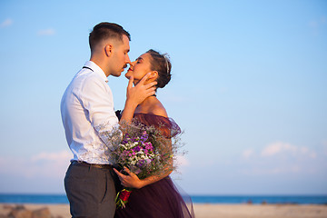 Image showing Young romantic couple relaxing on the beach watching the sunset