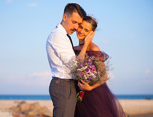 Image showing Young romantic couple relaxing on the beach watching the sunset