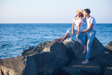 Image showing Happy young romantic couple relaxing on the beach watching the sunset