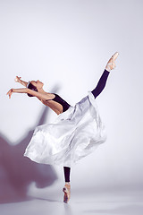 Image showing Ballerina in black outfit posing on toes, studio background.