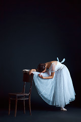 Image showing Portrait of the classical ballerina in white dress on black background