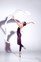 Image showing Ballerina in black outfit posing on toes, studio background.