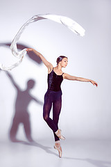 Image showing Ballerina in black outfit posing on toes, studio background.