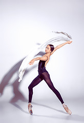 Image showing Ballerina in black outfit posing on toes, studio background.