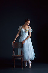 Image showing Portrait of the classical ballerina in white dress on black background