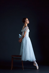 Image showing Portrait of the classical ballerina in white dress on black background