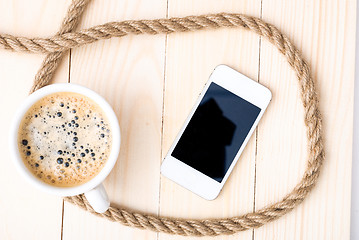 Image showing Cup of coffee with foam on wooden table