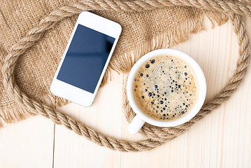 Image showing Cup of coffee with foam on wooden table