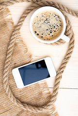 Image showing Cup of coffee with foam on wooden table