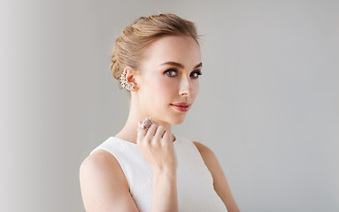 Image showing smiling woman in white dress with diamond jewelry