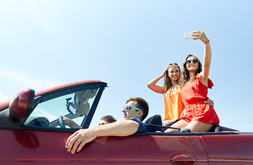 Image showing friends driving in cabriolet car and taking selfie