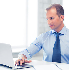 Image showing miling businessman working in office