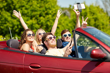 Image showing friends driving in cabriolet car and taking selfie