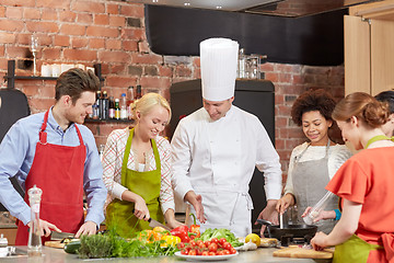 Image showing happy friends and chef cook cooking in kitchen