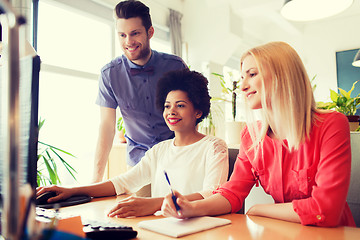 Image showing happy creative team with computer in office