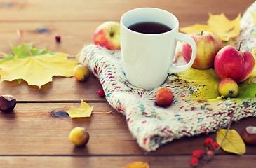 Image showing close up of tea cup on table with autumn leaves