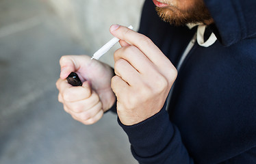 Image showing close up of addict smoking marijuana joint