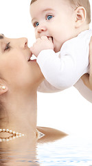 Image showing happy mother playing with baby boy in water