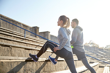 Image showing couple stretching leg on stands of stadium