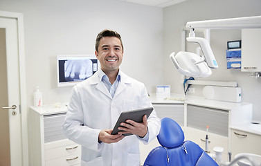 Image showing happy male dentist with tablet pc at dental clinic