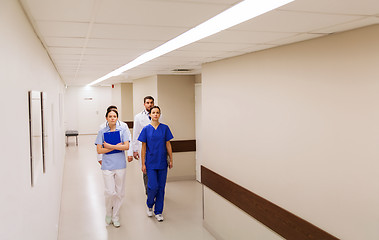 Image showing group of medics or doctors walking along hospital