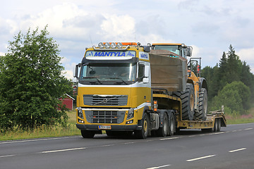 Image showing Volvo FH16 Semi Hauls Wheel Loader Through Rural Scenery