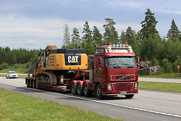 Image showing Volvo FH Hauls Cat 349E Tracked Excavator