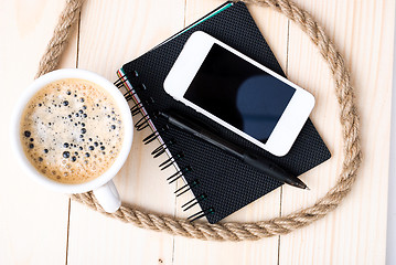 Image showing Smartphone with notebook and cup of strong coffee