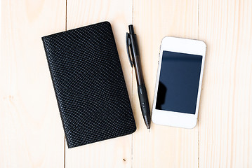 Image showing Small notepad with pen and smartphone