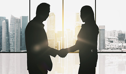 Image showing business partners silhouettes making handshake