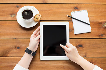 Image showing close up of woman with tablet pc on wooden table