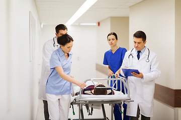 Image showing medics with woman on hospital gurney at emergency