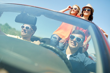 Image showing happy friends driving in cabriolet car