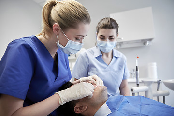 Image showing female dentist checking patient dental occlusion