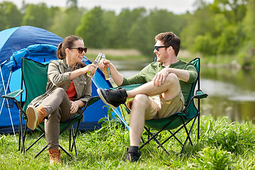 Image showing happy couple clinking drinks at campsite tent