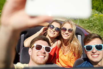 Image showing friends driving in cabriolet car and taking selfie