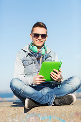 Image showing happy young man with tablet pc and headphones