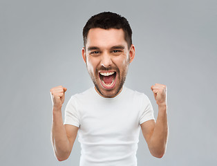 Image showing young man celebrating victory over gray