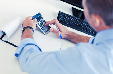 Image showing businessman with notebook and calculator