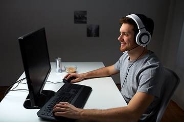 Image showing man in headset playing computer video game at home