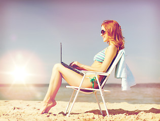 Image showing girl looking at tablet pc on the beach