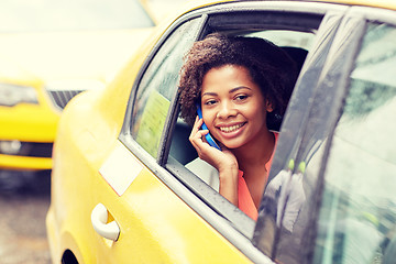 Image showing happy african woman calling on smartphone in taxi