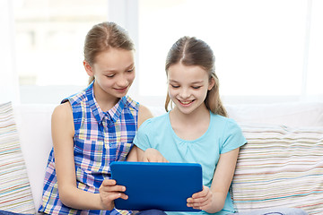 Image showing happy girls with tablet pc sitting on sofa at home