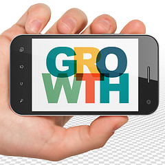 Image showing Business concept: Hand Holding Smartphone with Growth on  display