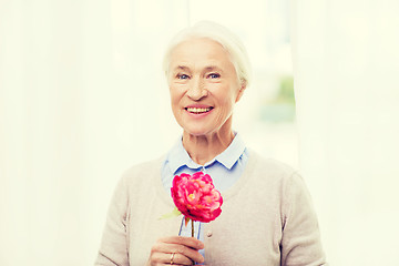 Image showing happy smiling senior woman with flower at home